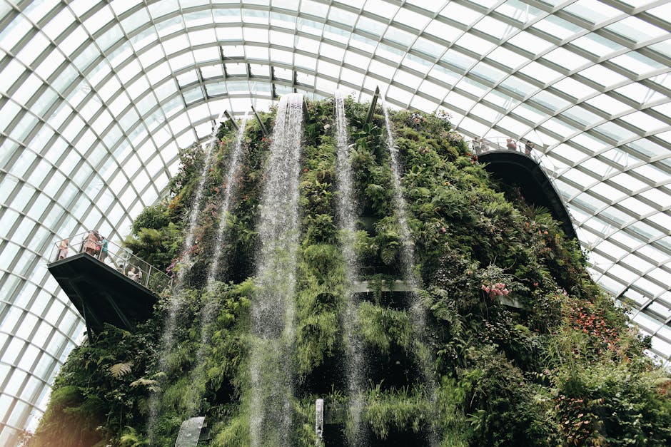Breathtaking indoor waterfall amidst lush greenery at Singapore's Gardens by the Bay.