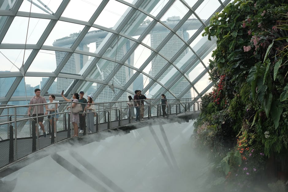 Tourists explore the Cloud Forest Dome at Gardens by the Bay, with Marina Bay Sands in the background.
